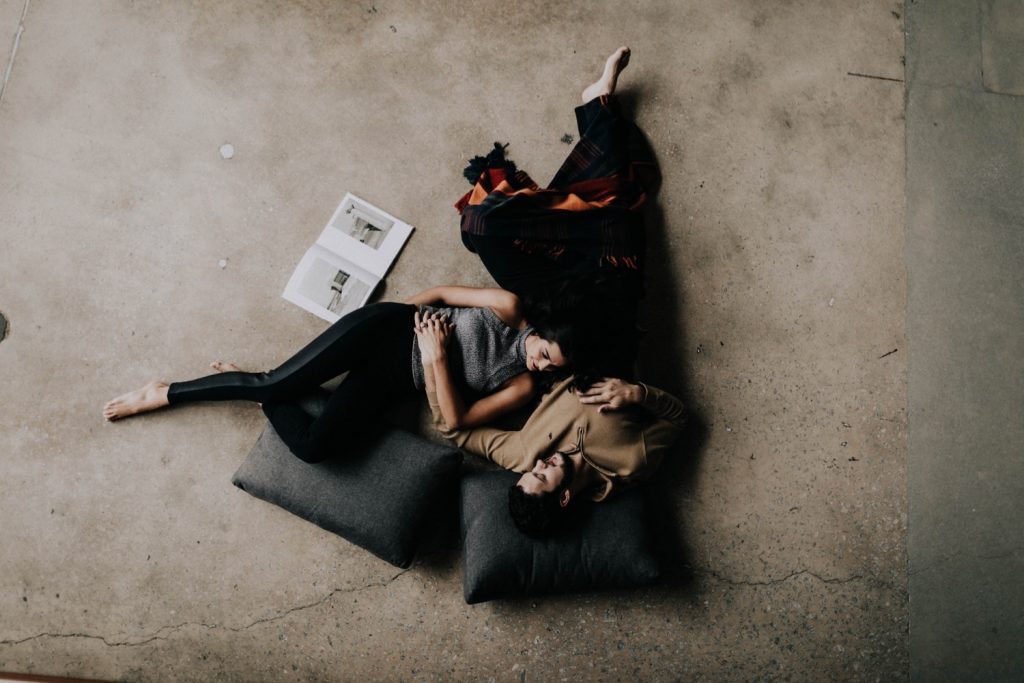engaged couple laying down together and relaxing during their at-home engagement photos