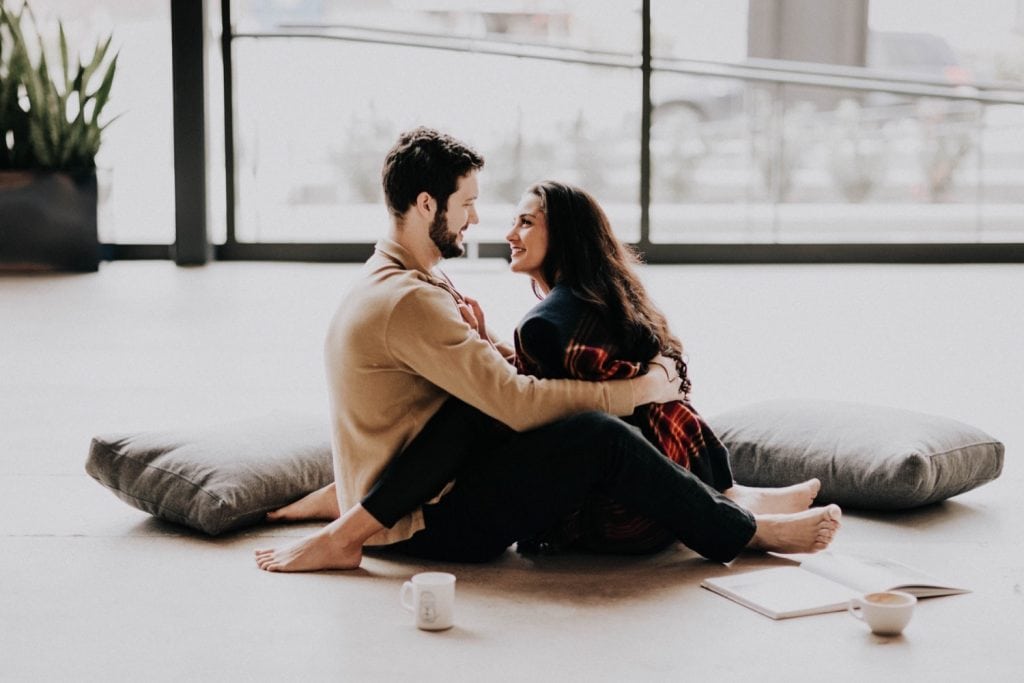 engaged couple drinking coffee and relaxing during their at-home engagement photos