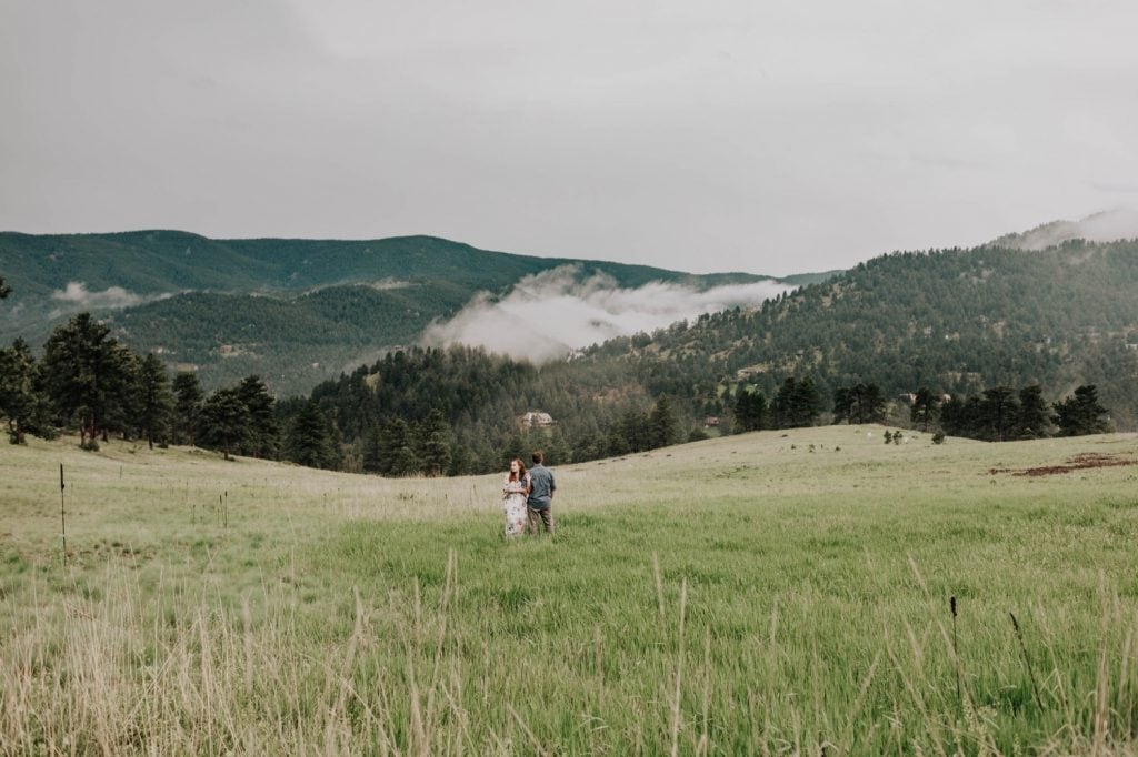 couple playing in a field together during their Boulder engagement photos in the foothills