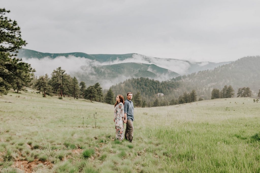 couple standing back to back during their Boulder engagement session