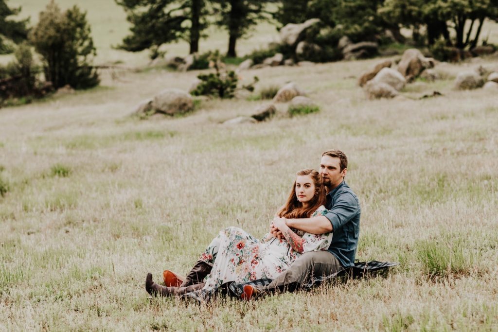 couple sitting together on the grass during their Boulder engagement photos