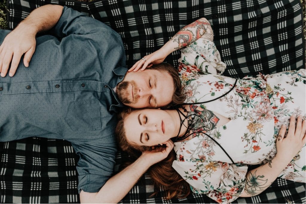 couple laying on a blanket and closing their eyes