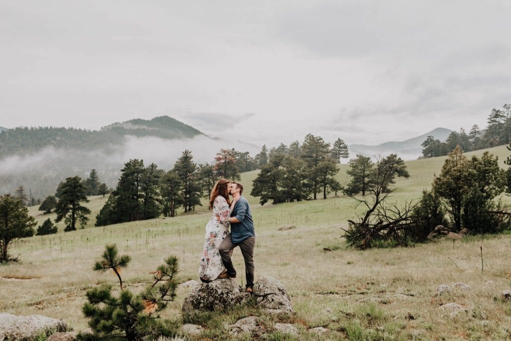 engaged couple wandering through an open field near Boulder Colorado
