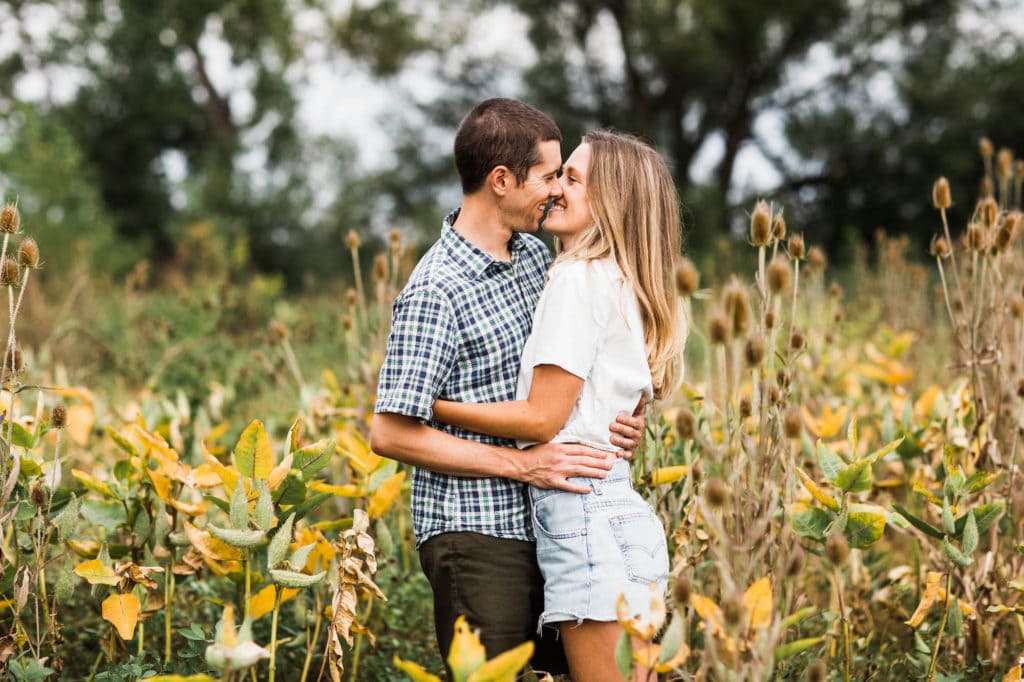 engagement photo locations in RMNP - engaged couple kissing in a flower meadow