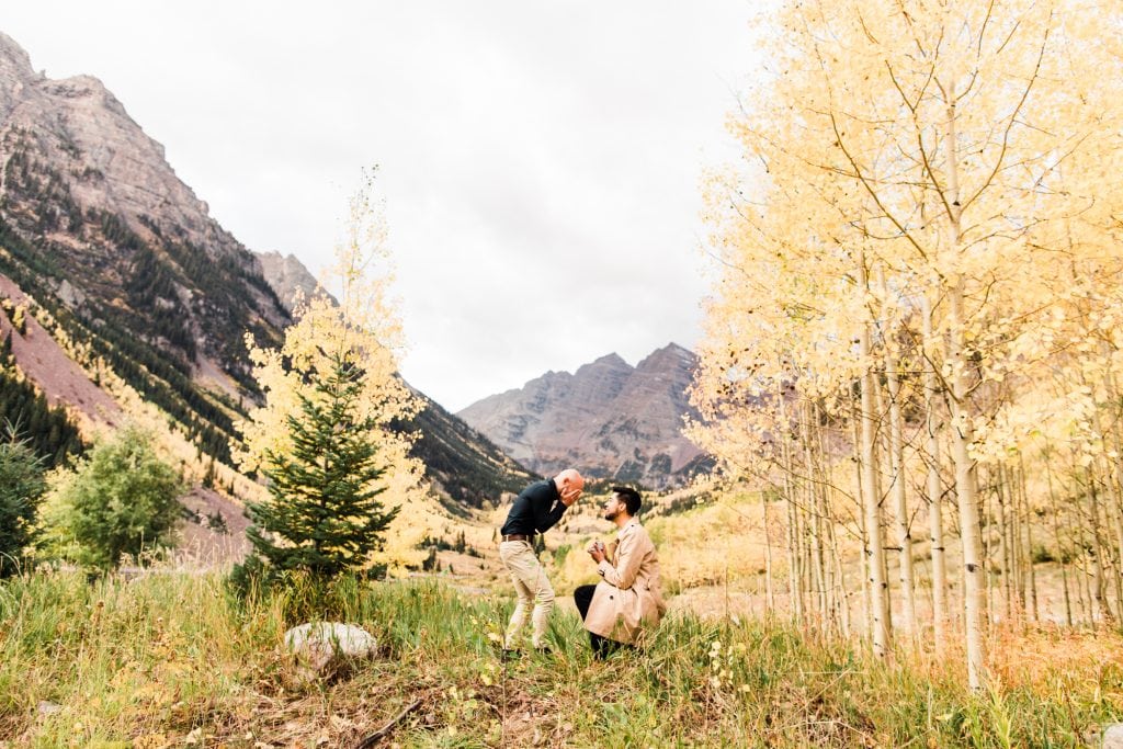 groom gets down on one knee to propose to his boyfriend at Maroon Bells in Aspen Colorado
