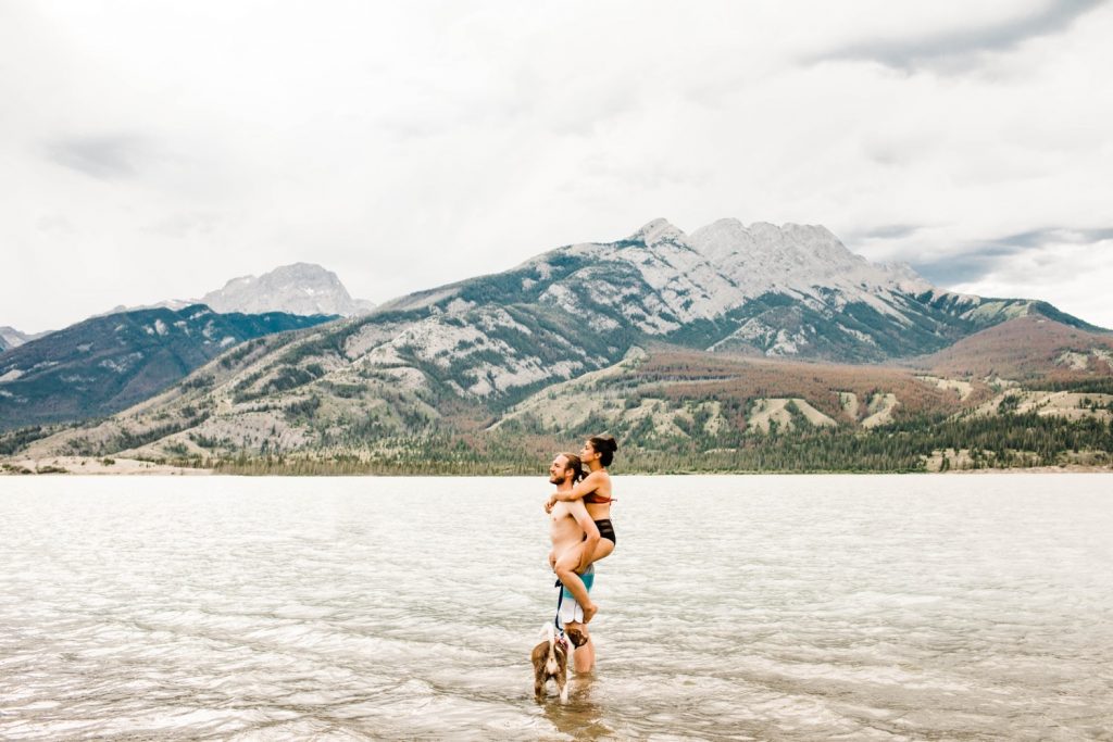 couple and their dog in an alpine lake