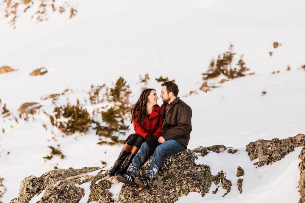 couple hiking a mountain during their snowy Colorado engagement photos in the Rocky Mountains of Colorado
