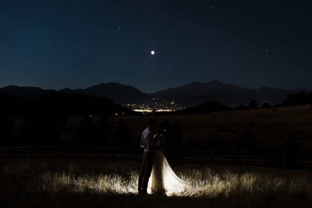 Elopement photo taken at night with a full moon in Estes Park