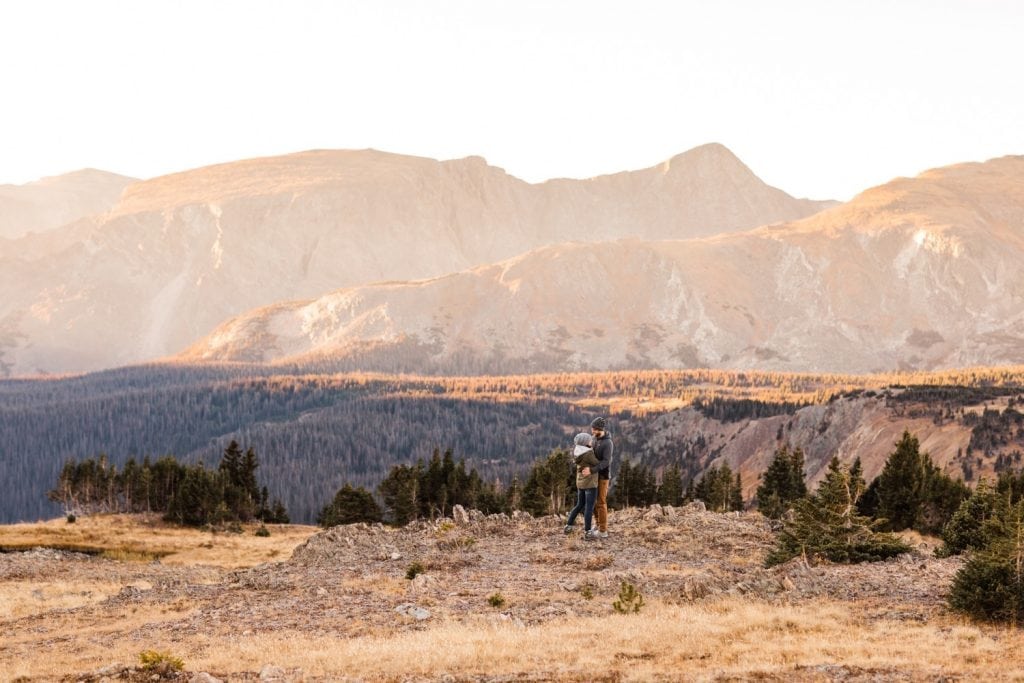 engaged couple adventuring through the Rocky Mountains during their national park engagement session in Colorado