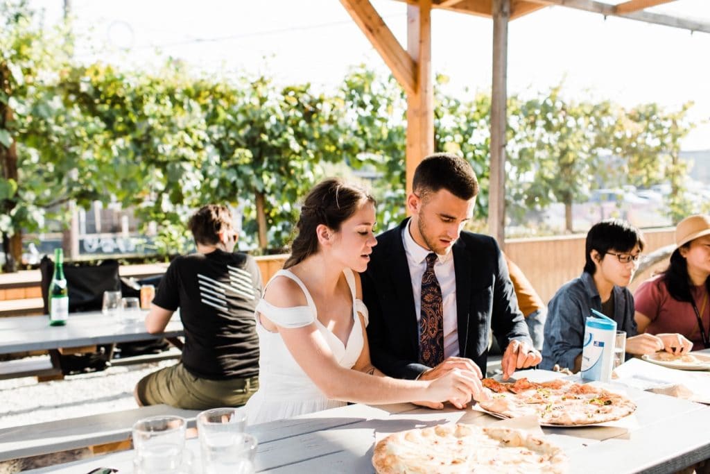 couple eating pizza at Humble Pie after their Mt Rainier elopement in a national park | Washington state elopements