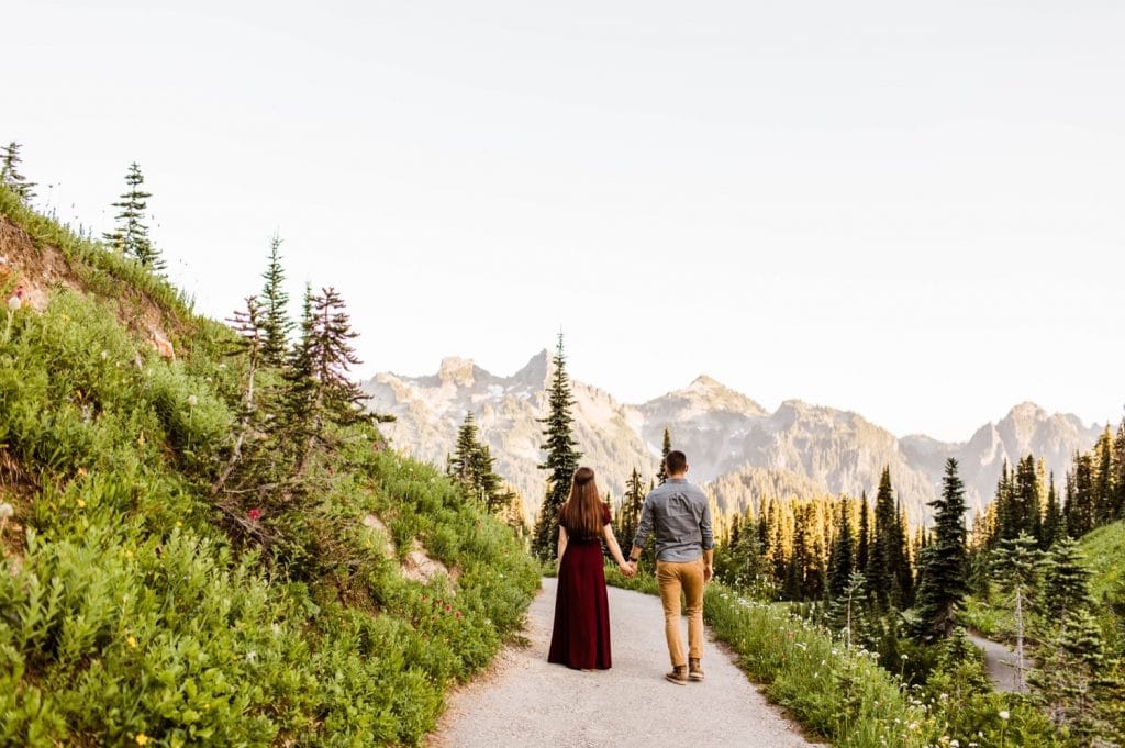 engaged couple walking down a hiking trail in a national park during their engagement photos in Seattle WA