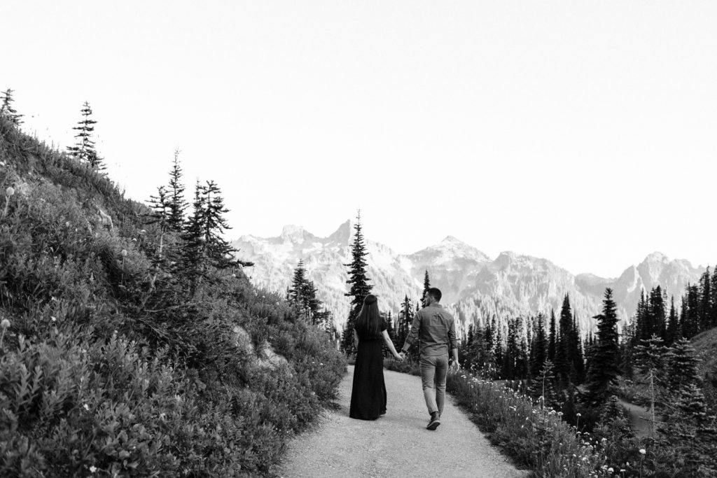 engaged couple walking down a hiking trail in a national park during their engagement photos in Seattle WA