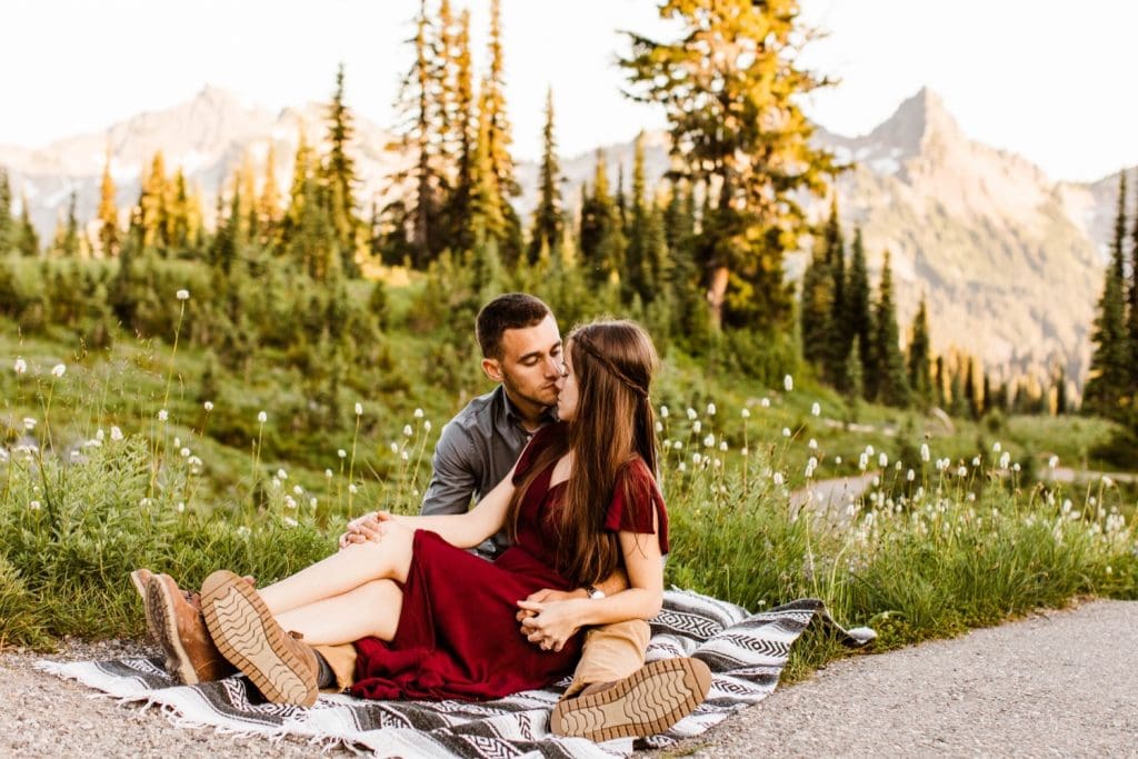 couple snuggling up on a blanket in the mountains during their engagement photos in Seattle WA