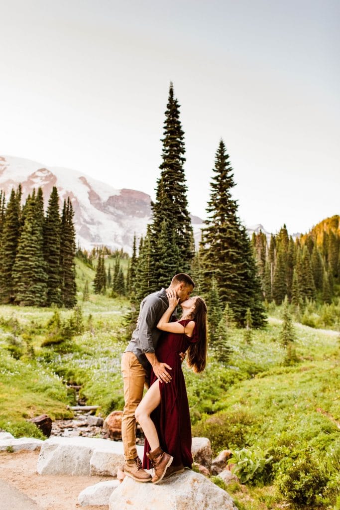 couple kissing in an alpine wildflower meadow during their engagement photos in Seattle WA