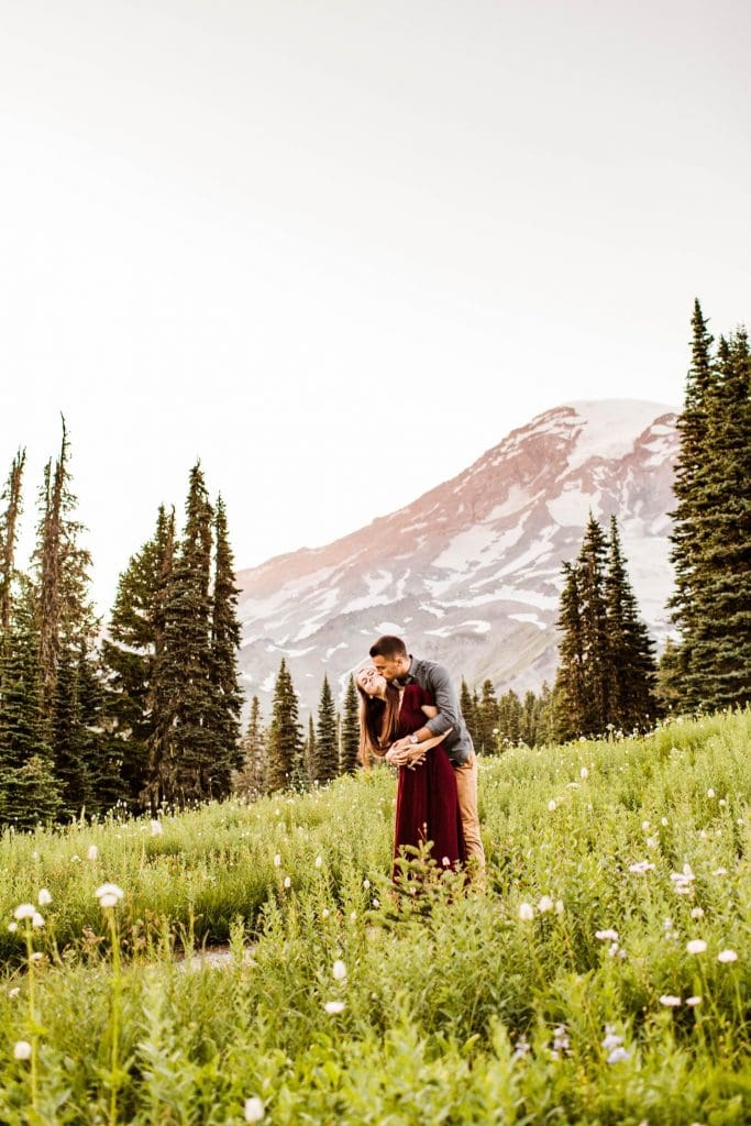 couple dancing together in an alpine wildflower meadow during their engagement photos in Seattle WA