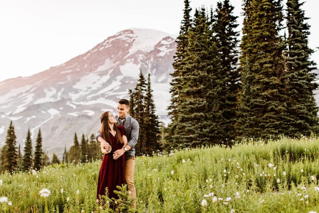 couple dancing together in an alpine wildflower meadow during their engagement photos in Seattle WA