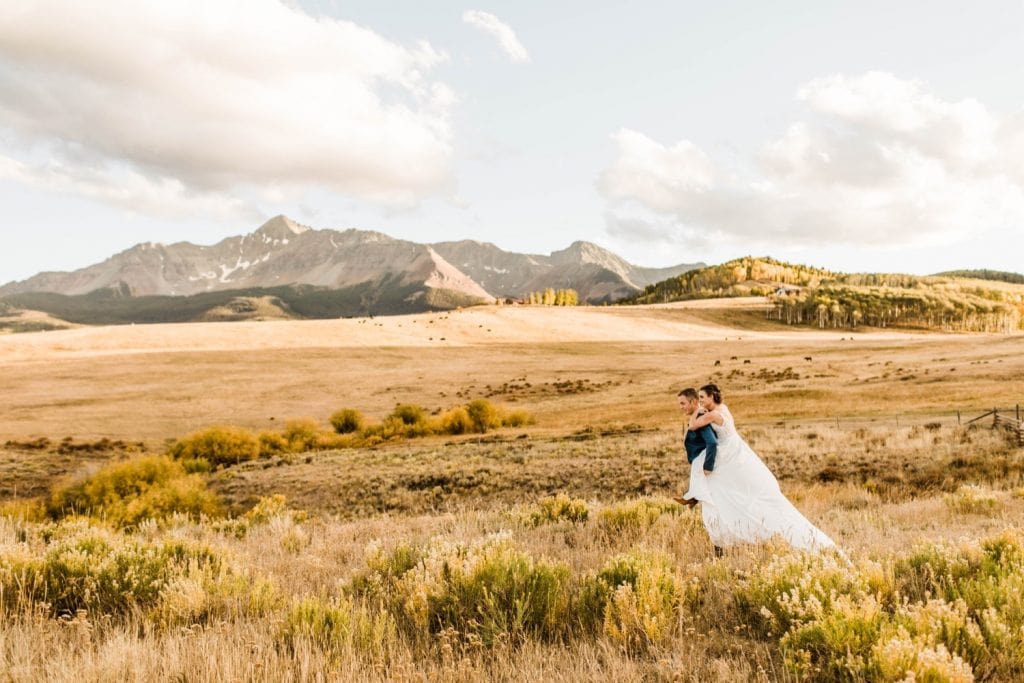 married couple running through the mountains during their Telluride wedding sunset photos | photographed by Telluride wedding photographers