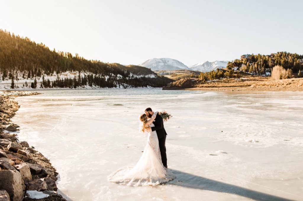 newly married couple standing on a frozen lake down the road after their Sapphire Point Overlook wedding