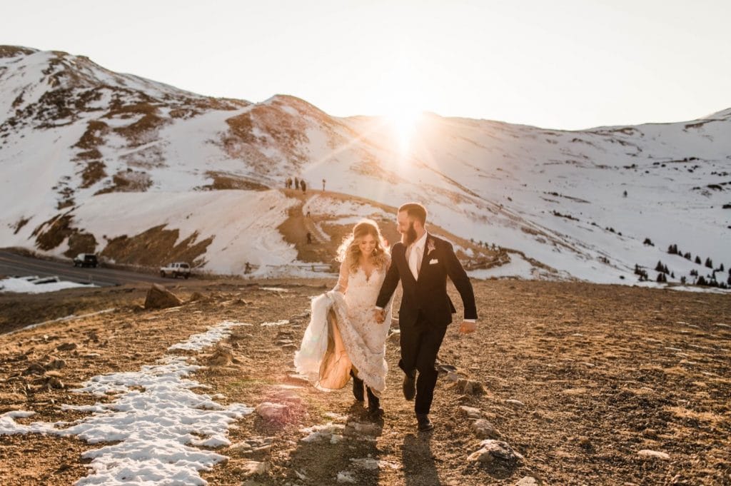 newly married couple running through the Rocky Mountains at sunset after their Sapphire Point Overlook wedding