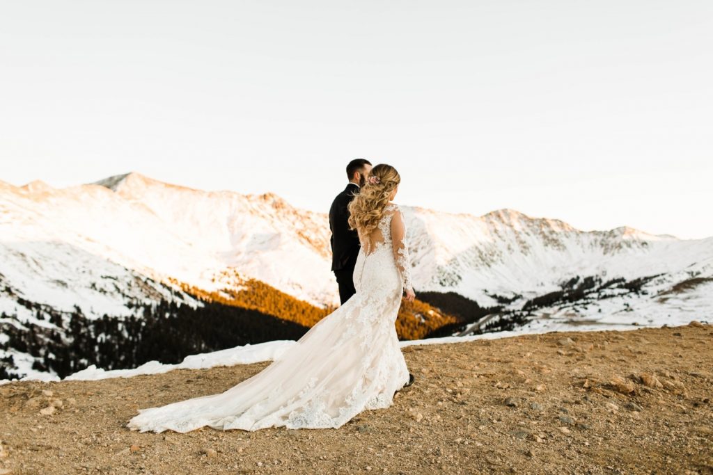 newly married couple walking on a hiking trail through the Rocky Mountains at sunset after their Sapphire Point Overlook wedding