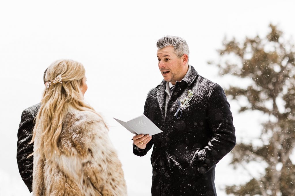 eloping couple reading their vows to each other during their winter Sapphire Point elopement ceremony