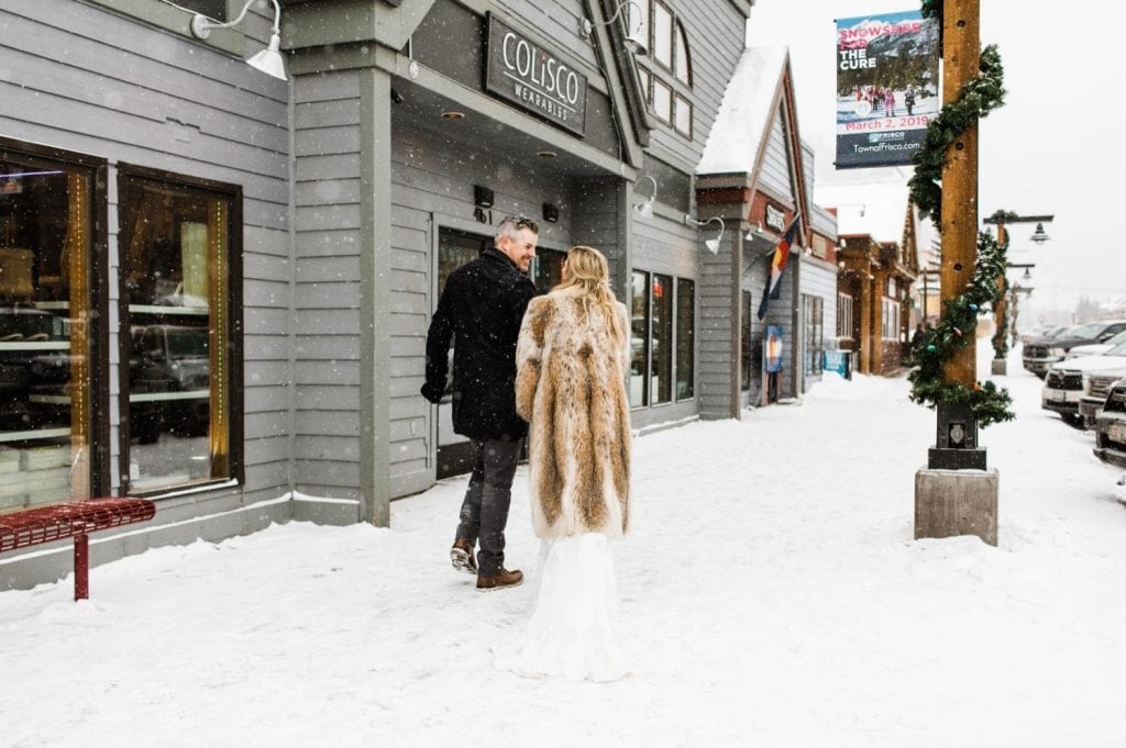 eloping couple picking up champagne in downtown Frisco Colorado after their snowy winter Sapphire Point elopement