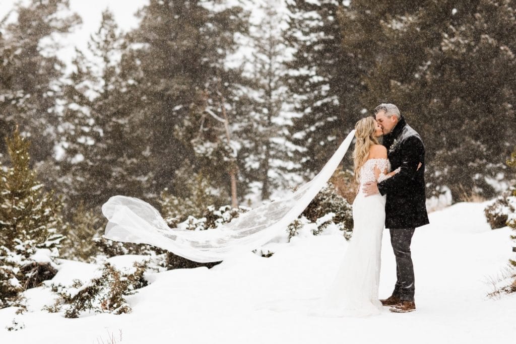 eloping couple kissing in the snowy mountains at Sapphire Point Overlook after their elopement