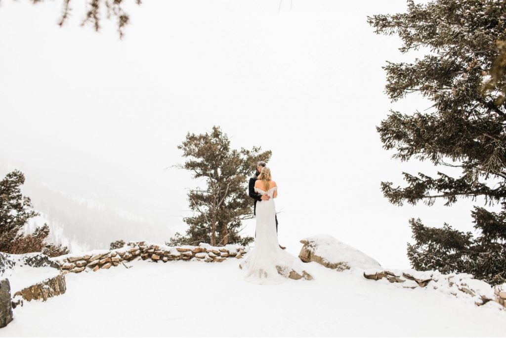 eloping couple snuggling up in the snow at Sapphire Point Overlook in Colorado