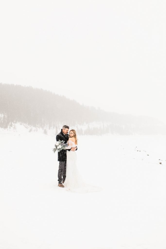 couple standing together in the snowy mountains after they eloped at Sapphire Point Overlook