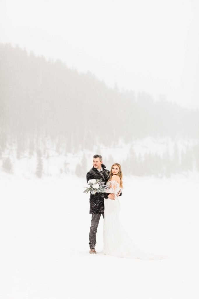 couple standing together in the snowy mountains after they eloped at Sapphire Point Overlook