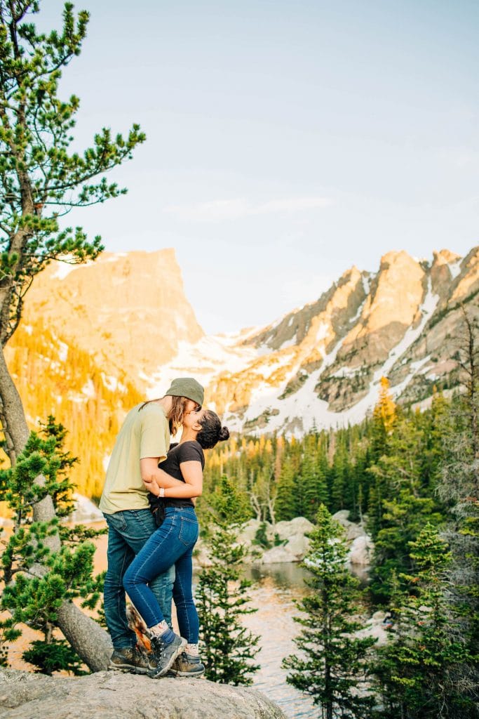 Fort Collins adventure elopement photographers kissing on the edge of a mountain at sunrise