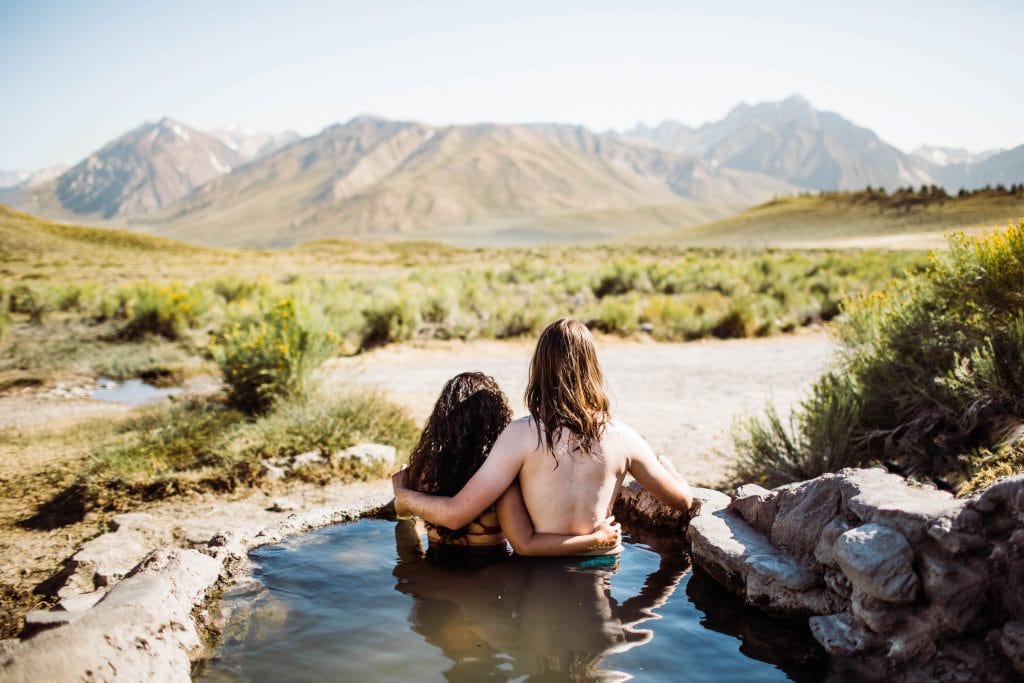 adventure elopement photographers soaking in a hot spring in the Sierra Nevada mountains