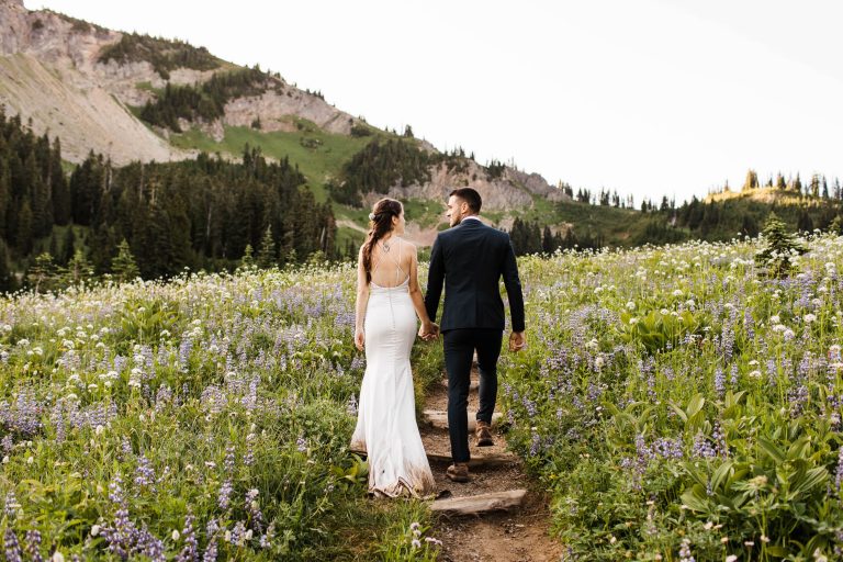 eloping couple hiking through mountains during their adventure wedding in Mt Rainier Washington State | taken by Colorado elopement photographers