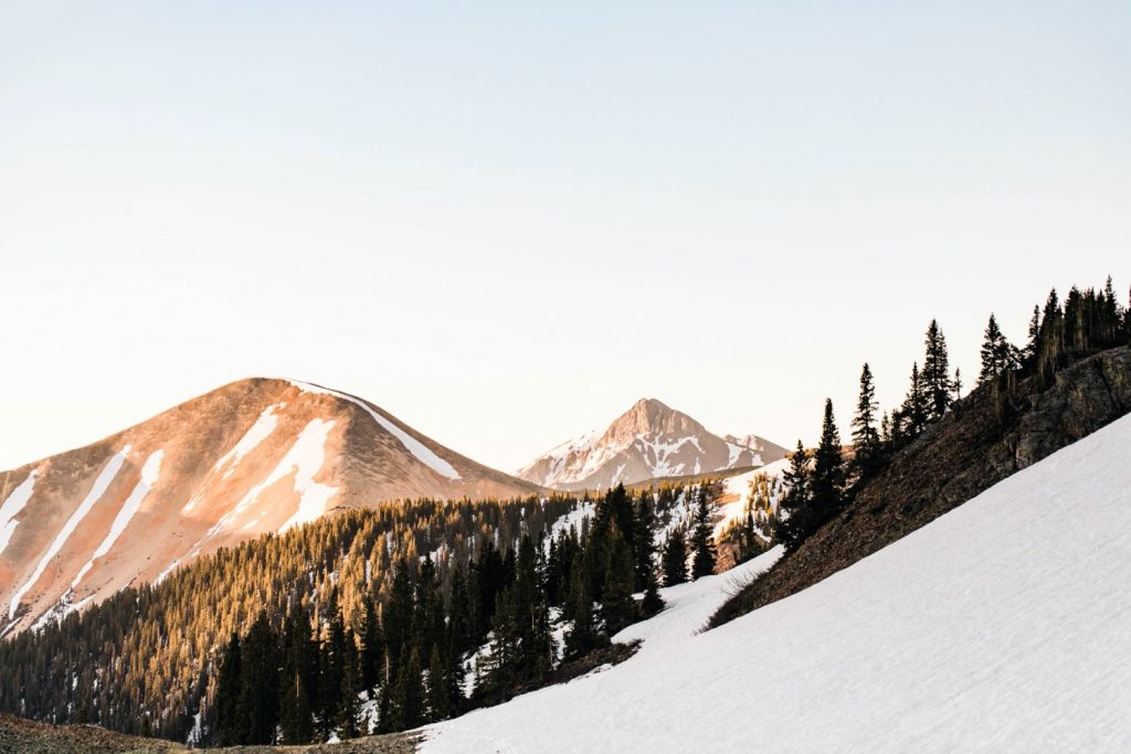Telluride elopement couple wrapped up in a blanket while watching the sun rise in the mountains
