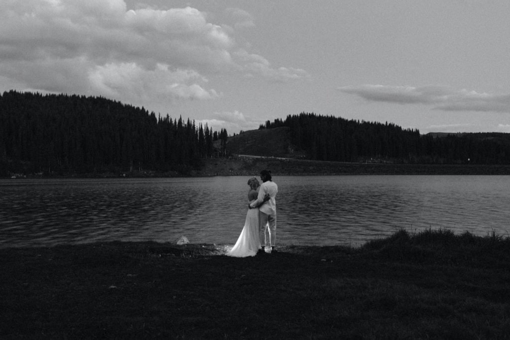couple hiking to their micro lake wedding in Colorado at dawn