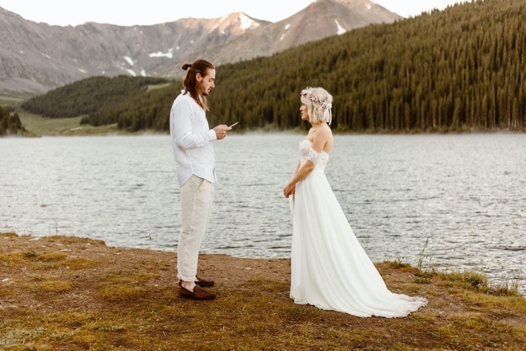 eloping couple reading their vows during their lake wedding ceremony in Colorado