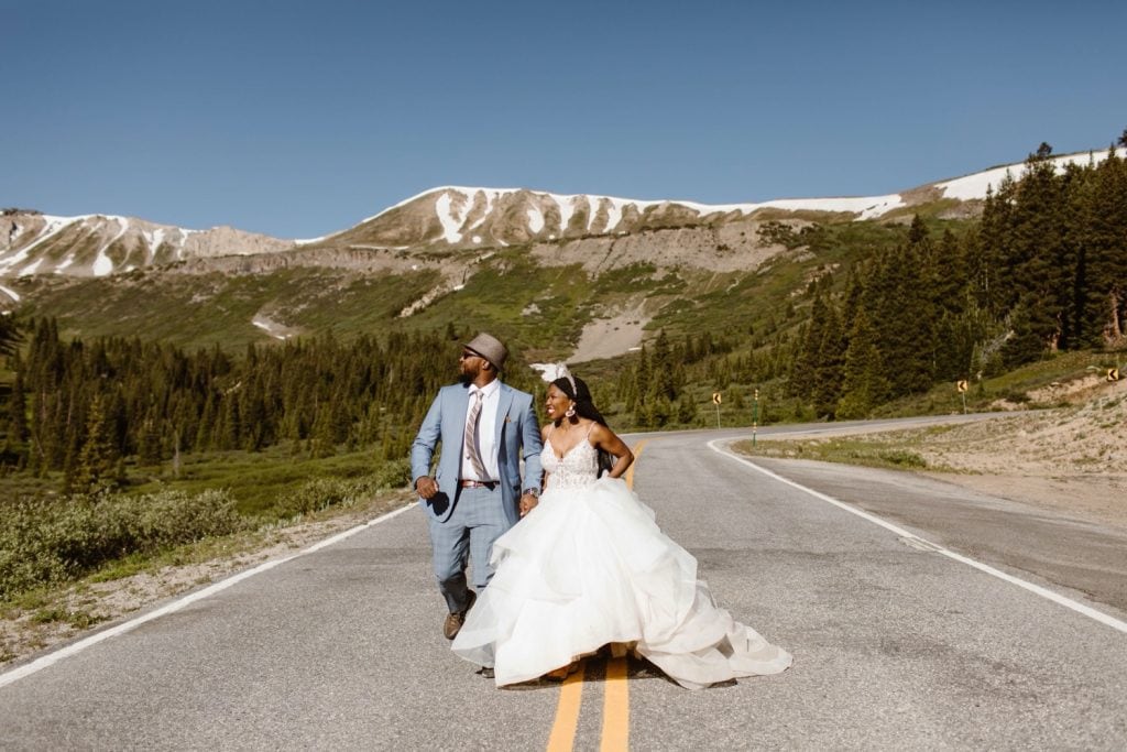 couple running on a mountain pass during their Aspen elopement