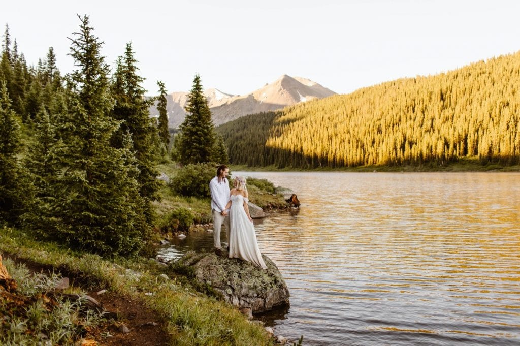eloping couple adventuring on a trail in the mountains during their lake wedding in Colorado