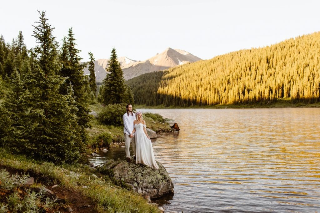 eloping couple adventuring on a trail in the mountains during their lake wedding in Colorado