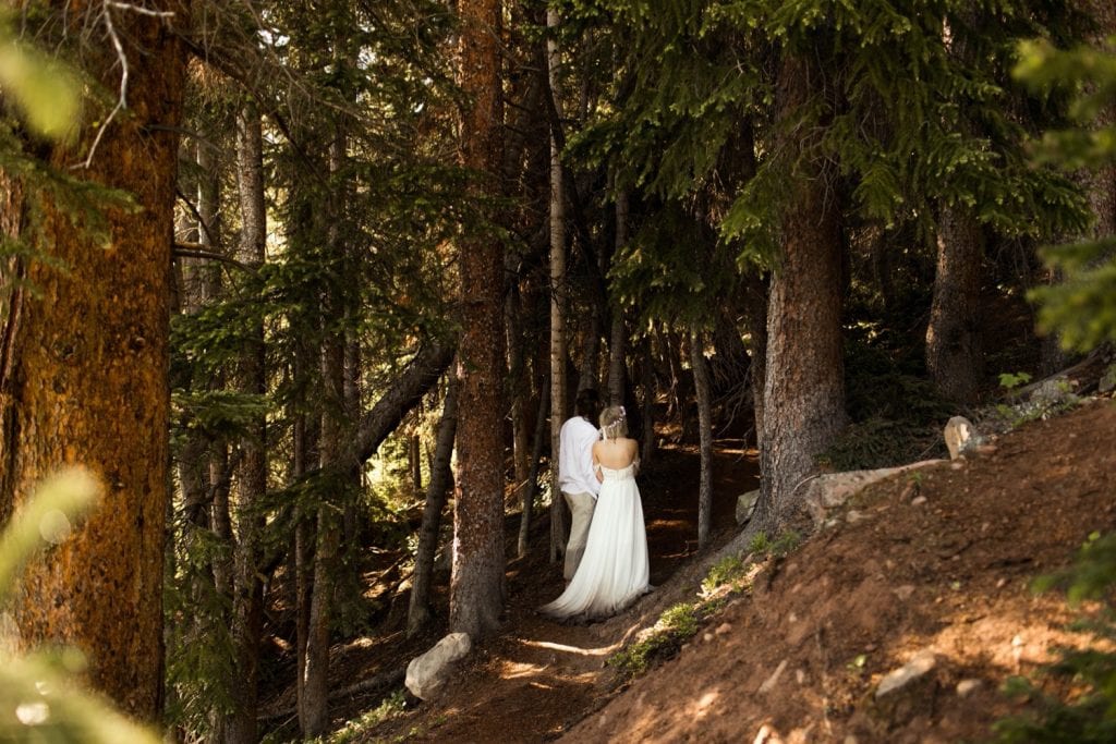 eloping couple hiking through the forest after their wedding