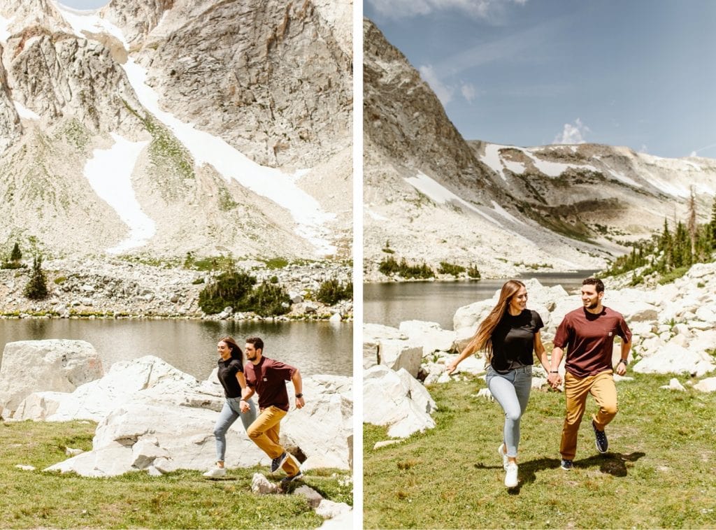 couple running through a field during their mountain engagement photos in Wyoming