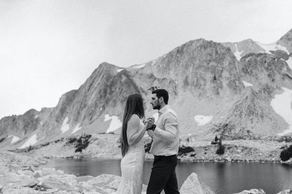 bride and groom sharing their vows during their Snowy Range Wyoming elopement by an alpine lake