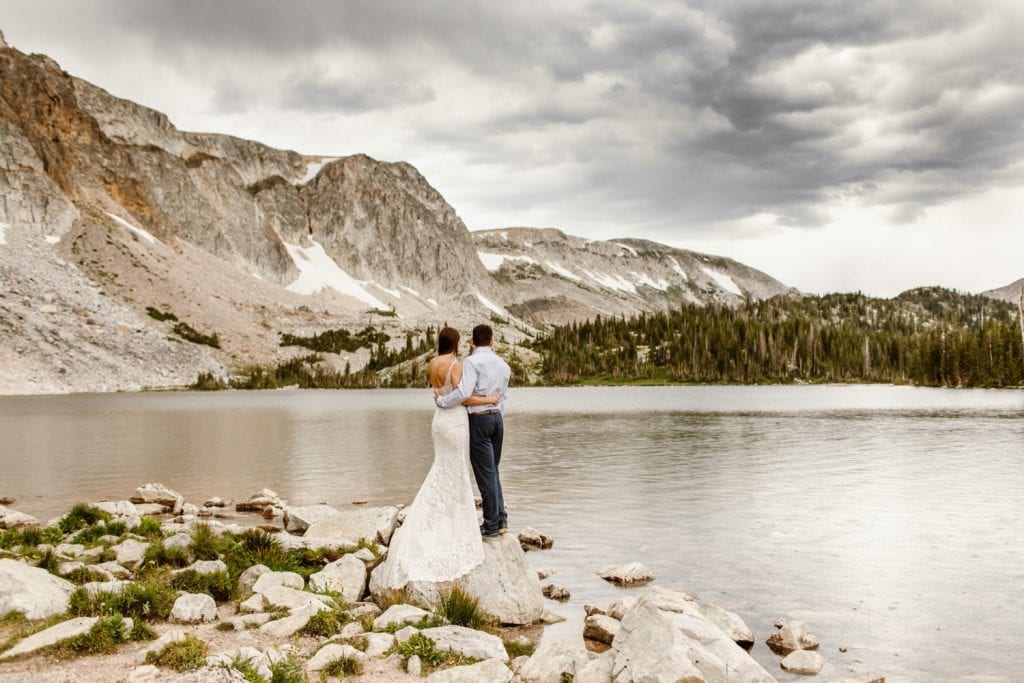 couple looking out onto an oncoming storm after their Snowy Range Wyoming elopement ceremony