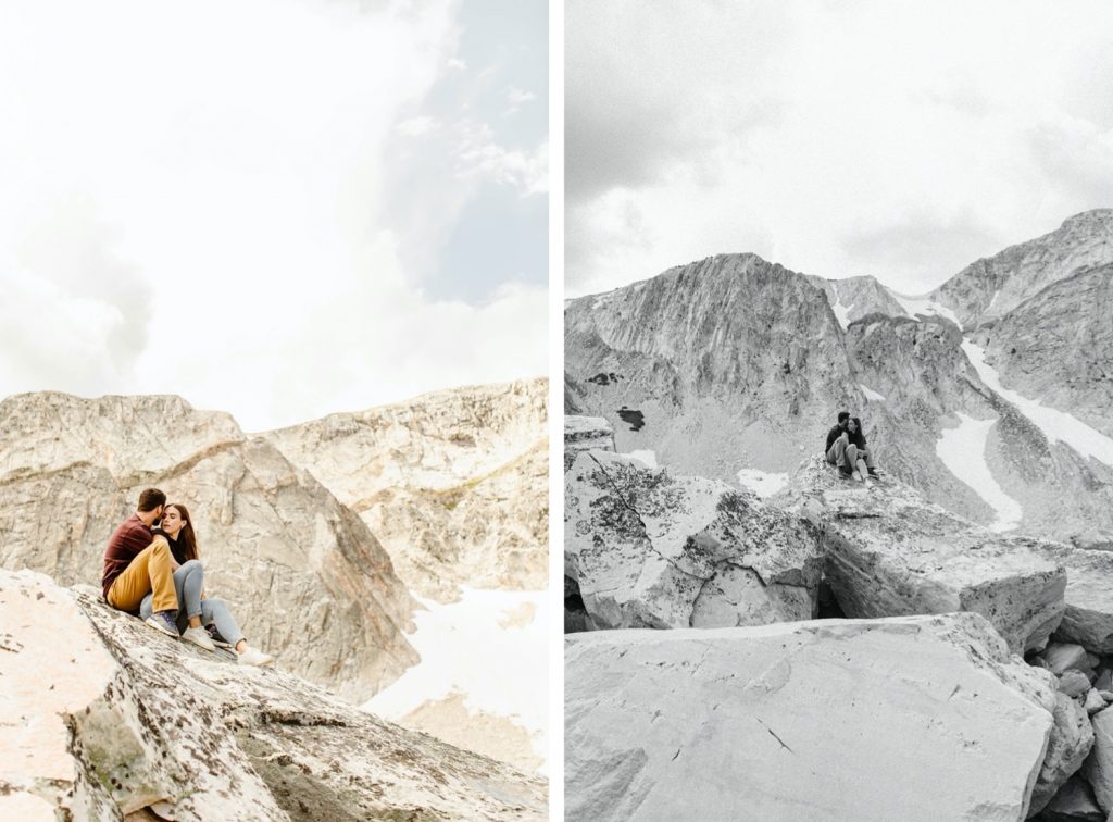 engaged couple sitting on a rocky mountain top during their mountain engagement photos in Wyoming