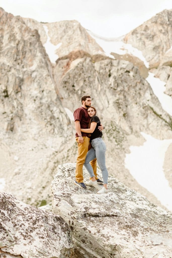 engaged couple standing on the top of a mountain in Wyoming