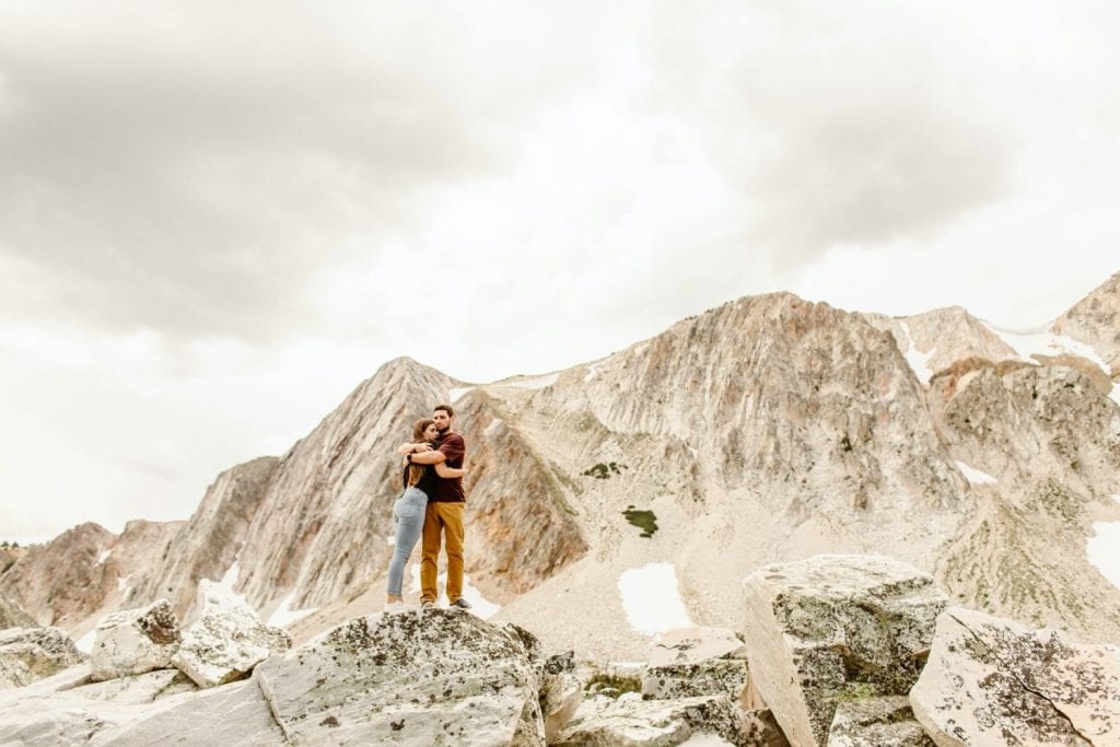 engaged couple hugging on a mountaintop in Wyoming