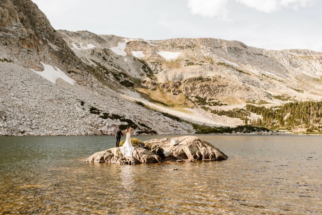 newly married couple adventuring on an alpine lake island after their small Wyoming wedding