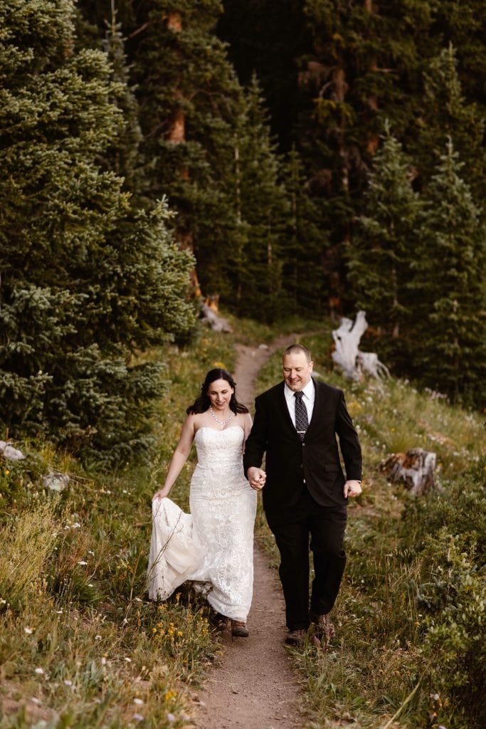 newly married couple running down the trail after they finished their destination elopement vows