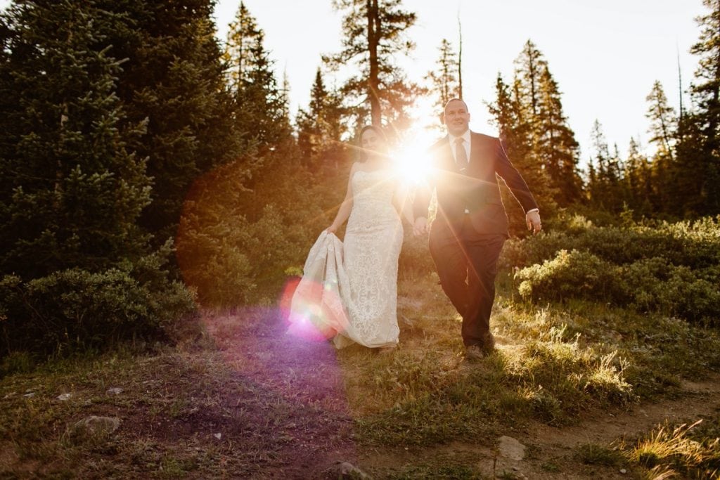 couple walking down a trail at sunrise after their elopement ceremony