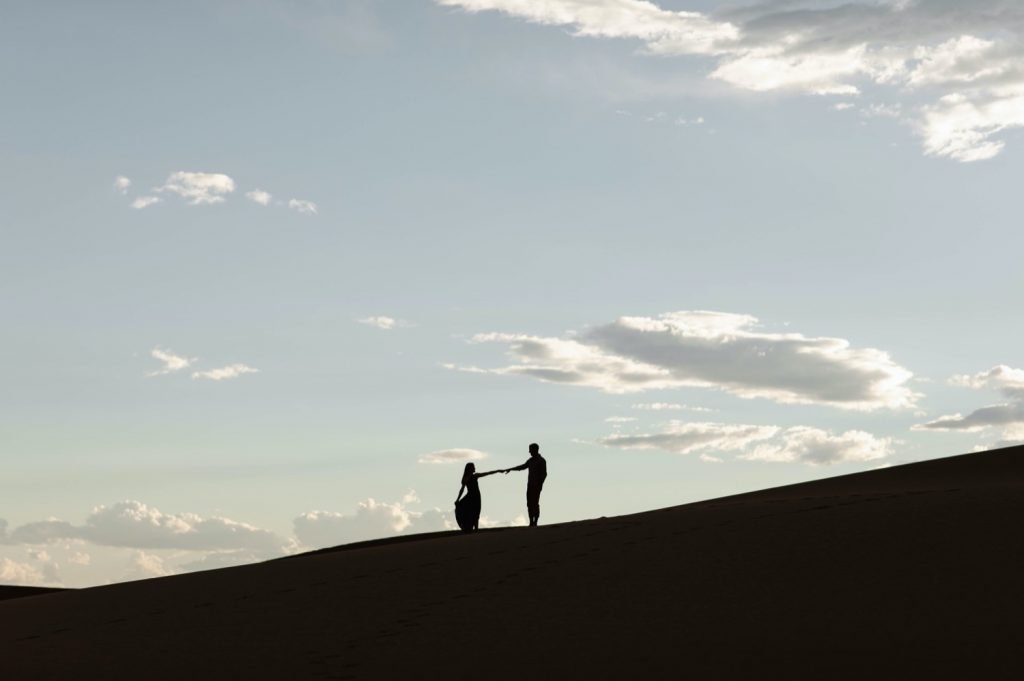 silhouette of a couple during their sand dunes engagement photos